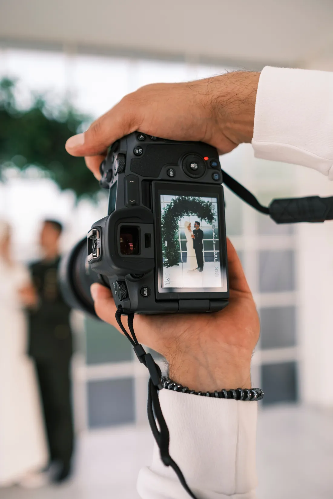 Photographer reviewing a portrait of the bride and groom on the back of the camera